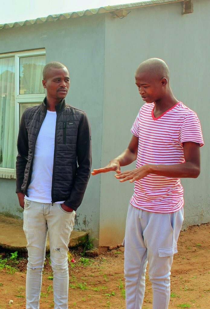 Des proches de Siya Kolisi devant sa maison d’enfance, Mthembu Street, à Zwide (à gauche Lungisa Madikane, ami d’enfance et à droite un cousin)